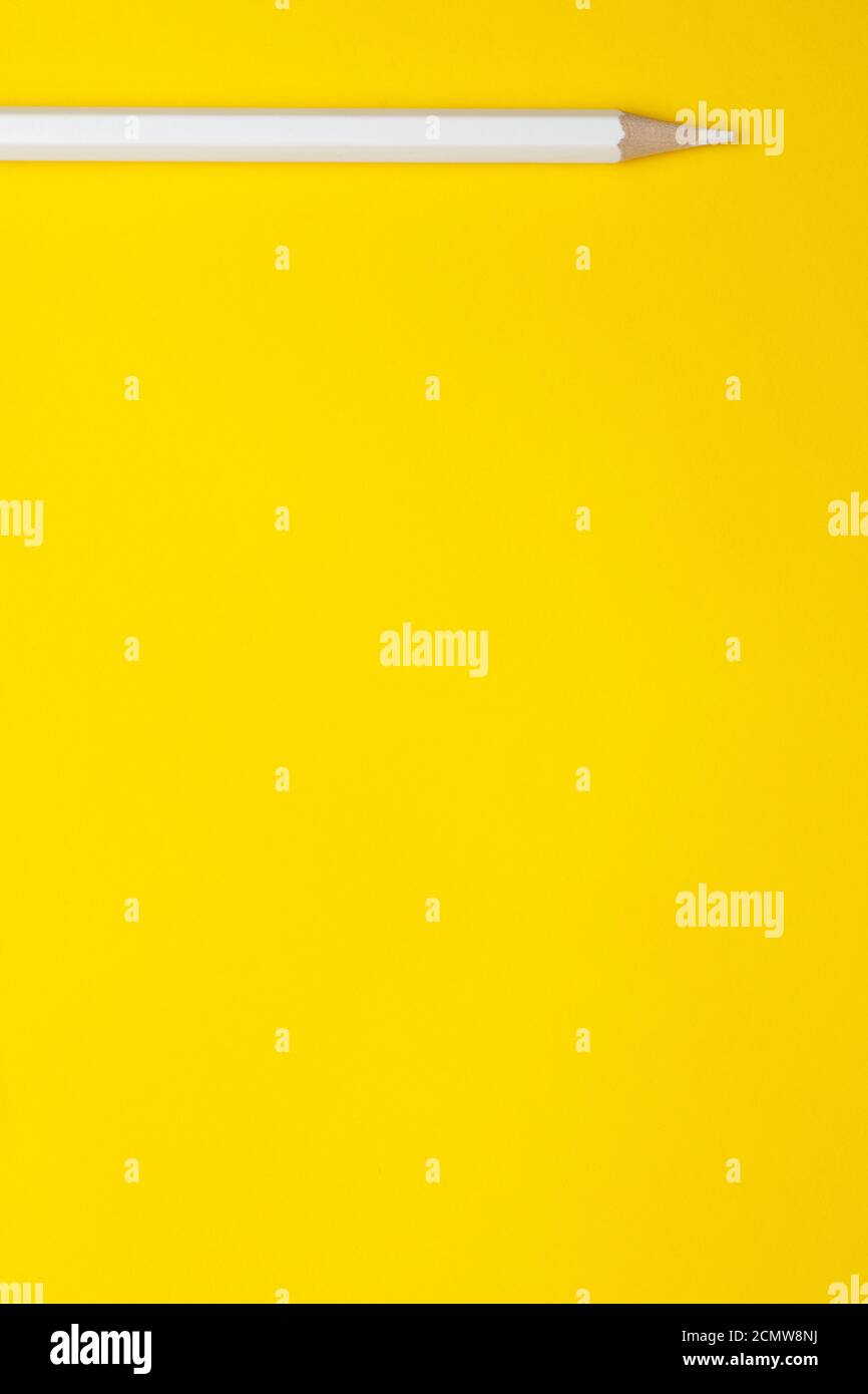 Vertical white sharp wooden pencil on a bright yellow background, isolated, copy space, mock up Stock Photo