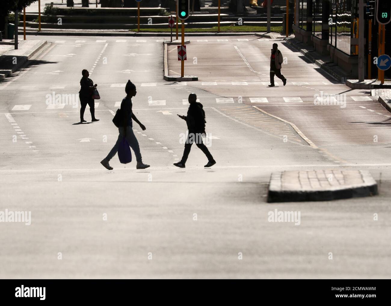 People cross a normally busy, but now largely empty, Adderley Street during the 21-day nationwide lockdown aimed at limiting the spread of the coronavirus disease (COVID-19) in central Cape Town, South Africa April 14, 2020. REUTERS/Mike Hutchings Stock Photo