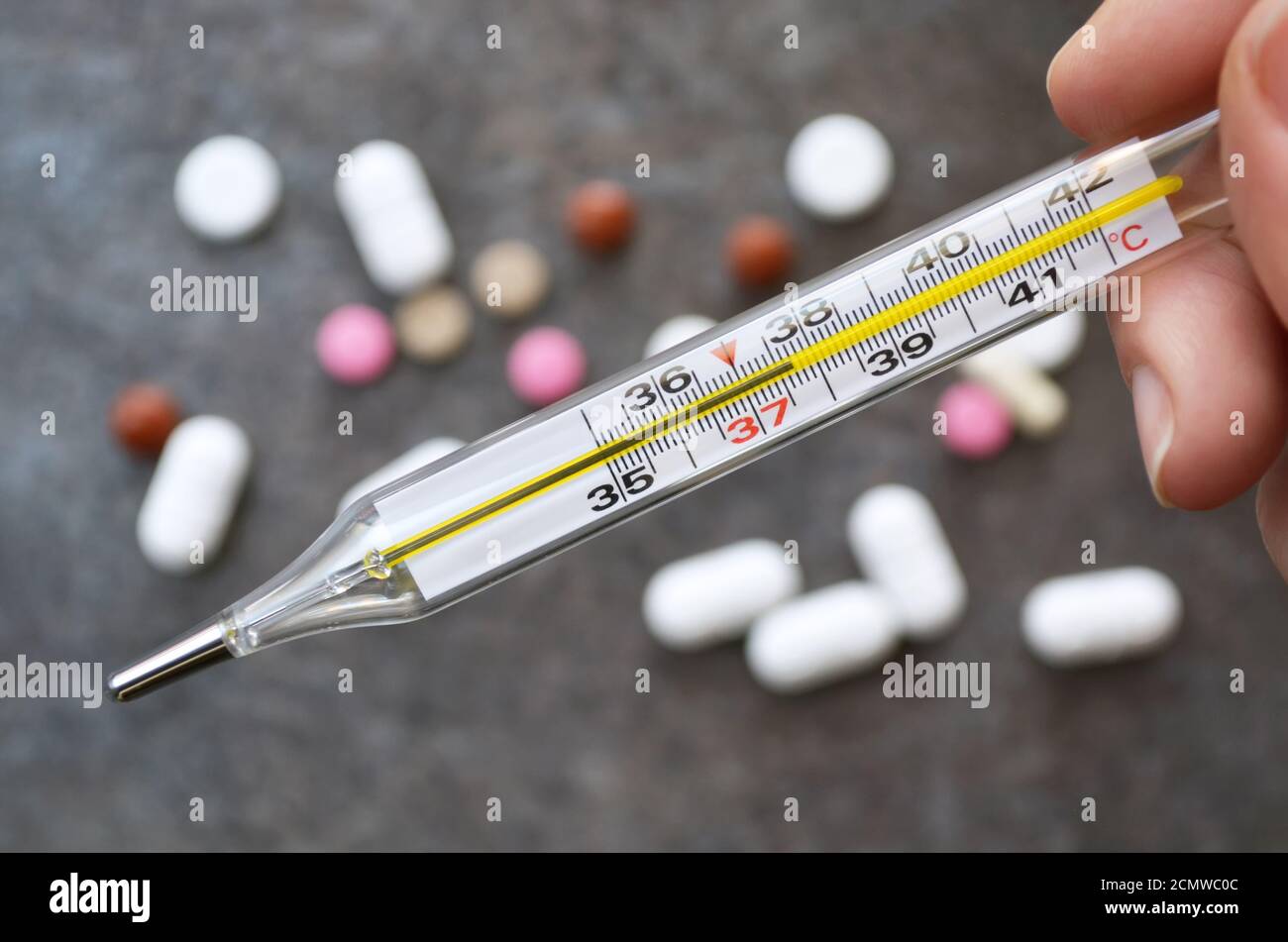 https://c8.alamy.com/comp/2CMWC0C/medical-thermometer-indicating-a-temperature-of-377-degrees-celsius-against-the-background-of-scattered-tablets-on-the-dark-gray-surface-of-the-table-2CMWC0C.jpg
