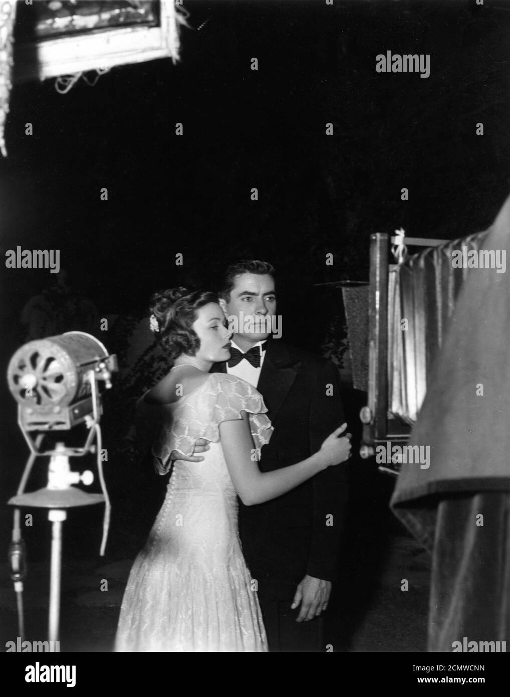 GENE TIERNEY and TYRONE POWER on set candid posing for the still camera during filming of party scene in THE RAZOR'S EDGE 1946 director EDMUND GOULDING novel W. Somerset Maugham screenplay Lamar Trotti  music Alfred Newman producer Darryl F. Zanuck Twentieth Century Fox Stock Photo