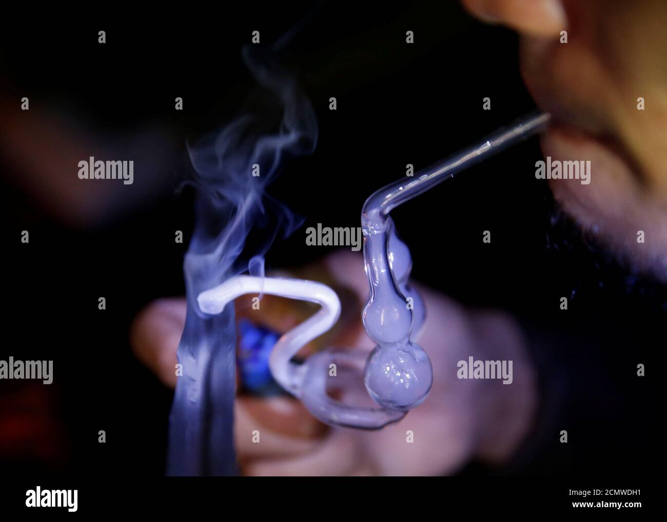 A Drug Addict Uses A Glass Water Pipe To Smoke Shabu Or Methamphetamine At An Undisclosed