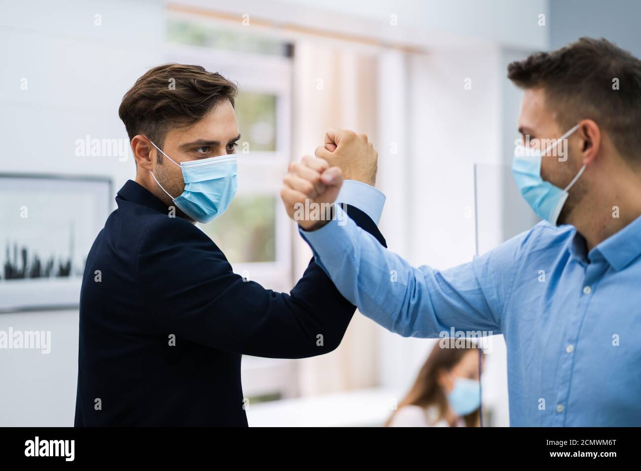Employees Doing Elbow Bump To Avoid Flu And Stop Covid Spread Stock Photo