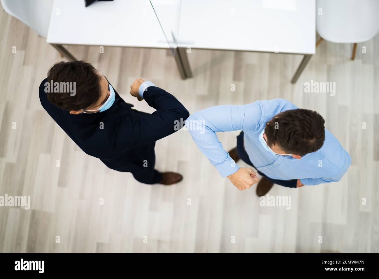 Employees Doing Elbow Bump To Avoid Flu And Stop Covid Spread Stock Photo