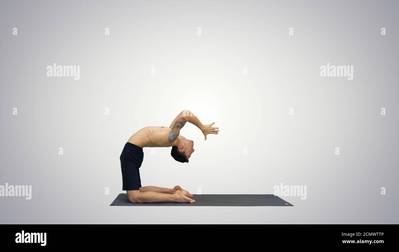 Yogi doing camel yoga pose on gradient background. Stock Photo