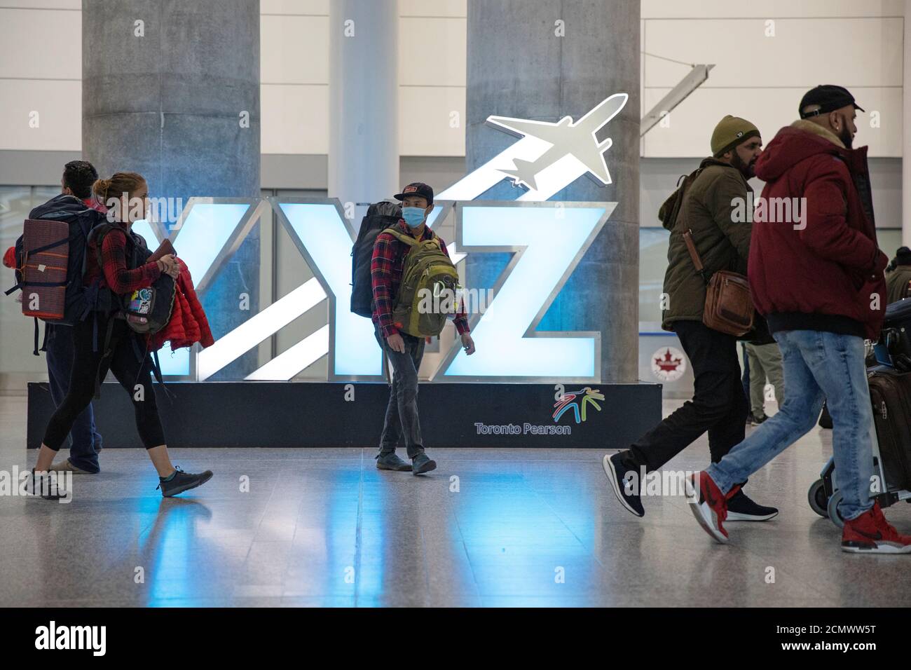 Travellers pass a YYZ airport code sign in the international arrivals lounge amid a growing global number of coronavirus cases at Pearson Airport in Toronto, Ontario, Canada March 13, 2020.  REUTERS/Chris Helgren Stock Photo