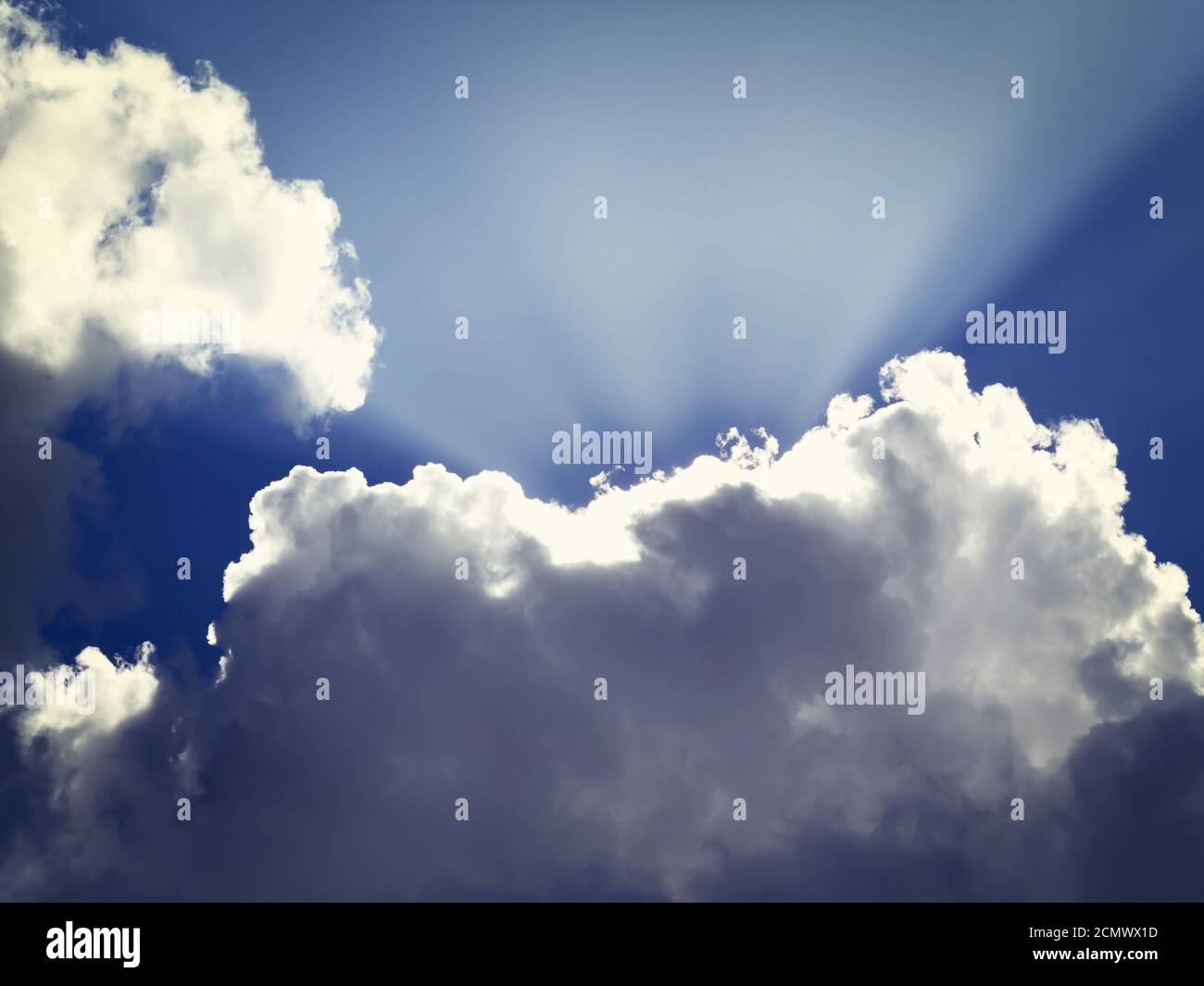 rays of the sun makes his way from behind the clouds Stock Photo