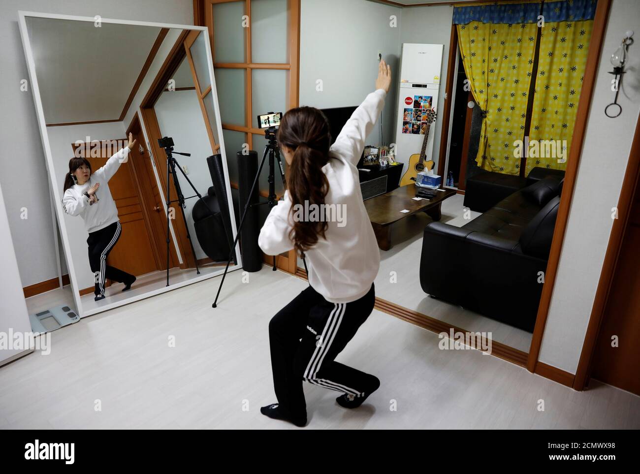 Kim Myung-hae, 46, a pre-school teacher, practices a dance by the South Korean boyband BTS as she watches a YouTube video at her home, during the novel coronavirus disease (COVID-19) outbreak, in Gumi, Gyeongsang Province, South Korea, March 13, 2020. Kim has been self-isolating since the end of February. 'Since I can't go outside, I do a lot of online shopping. I surf the internet a lot too... I tend to watch a lot of YouTube,' Kim said. 'I miss everyday life. It all feels more special now. Before the coronavirus came, I went out everyday and would meet people all the time. I actually enjoyed Stock Photo