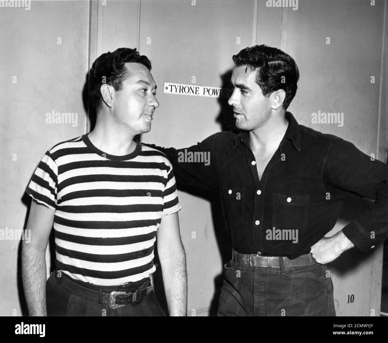TYRONE POWER outside his Dressing Room with his Stand-In TOMMY NOONAN on set candid during filming of THE RAZOR'S EDGE 1946 director EDMUND GOULDING novel W. Somerset Maugham screenplay Lamar Trotti  music Alfred Newman producer Darryl F. Zanuck Twentieth Century Fox Stock Photo