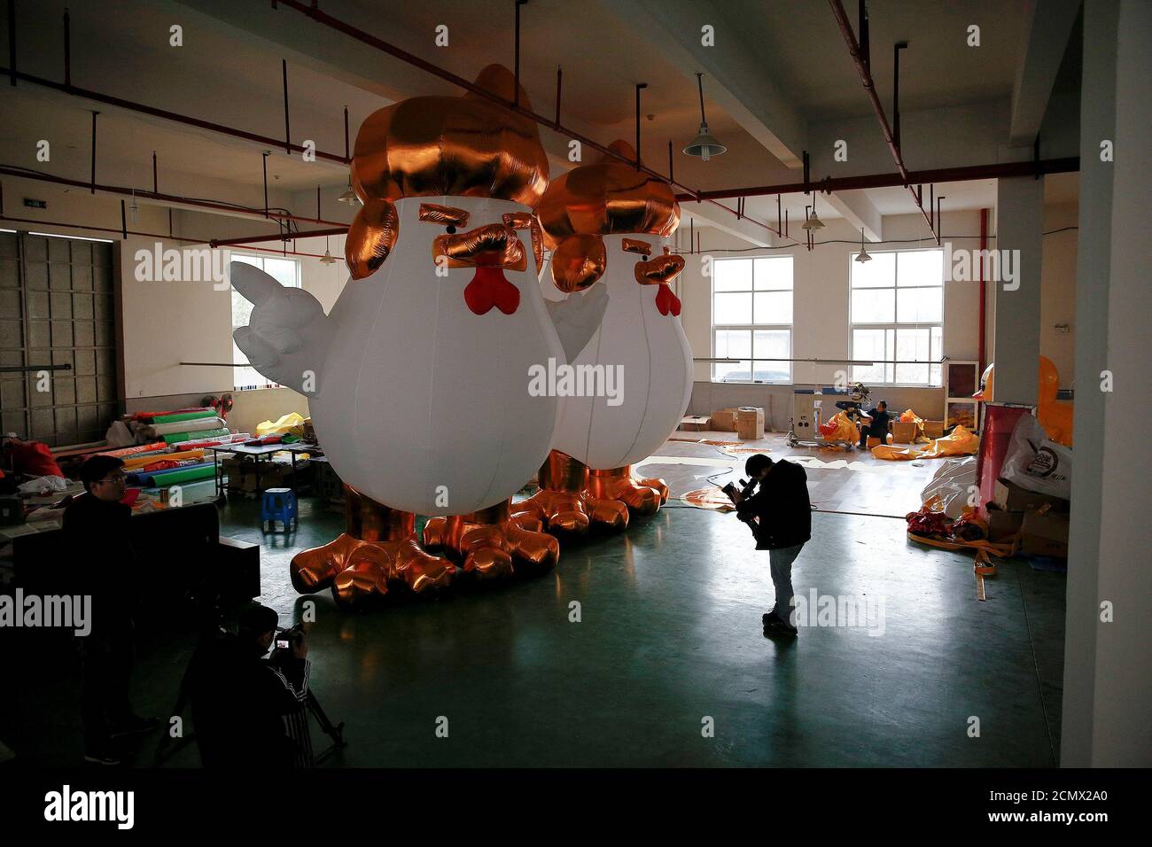 A cameraman films an inflatable chicken that local media say bears resemblance to U.S. President-elect Donald Trump as a Chinese factory braces for the Year of the Rooster in Jiaxing, Zhejiang province, China January 12, 2017. REUTERS/Aly Song Stock Photo