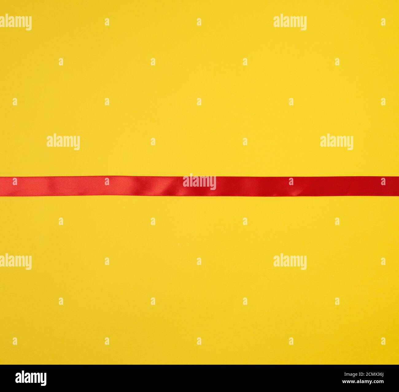 red silk ribbon on a yellow background, festive backdrop Stock Photo ...