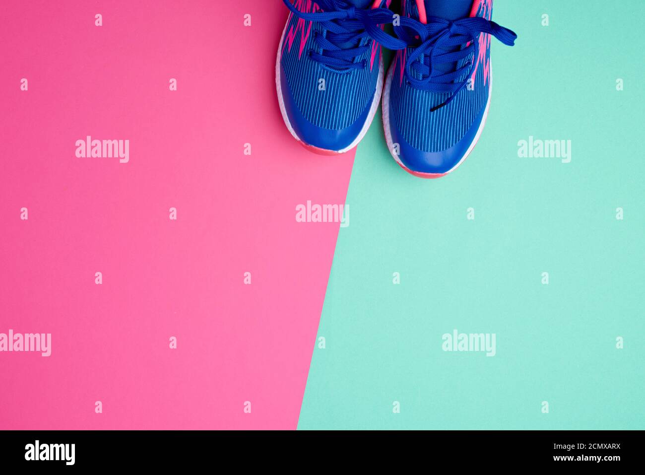 pair of sports sneakers with blue laces on a colored abstract
