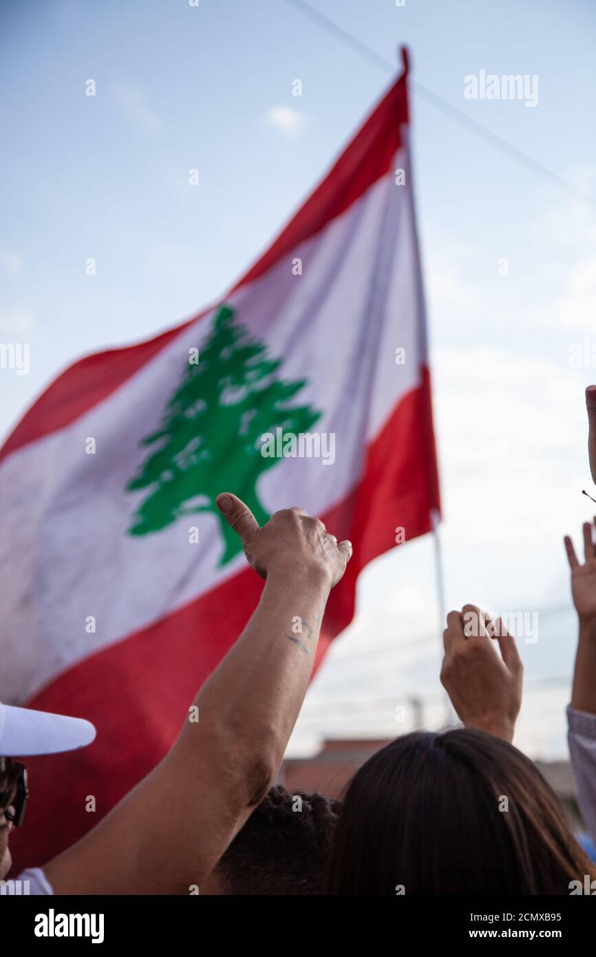 Lebanese Protesters rising Lebanon Flag in the Sky at the Revolution against the Government Stock Photo
