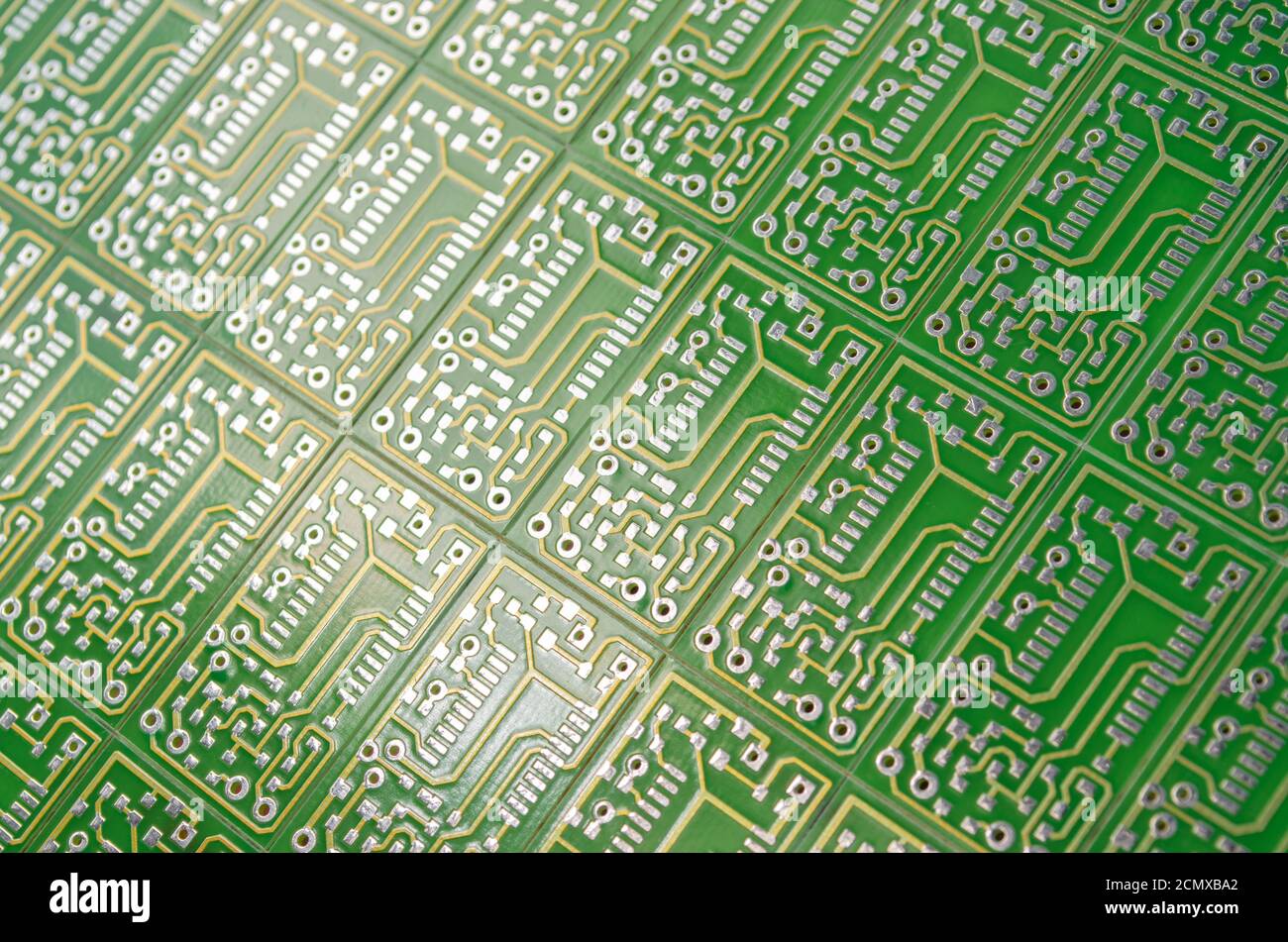 Close-up of a green electronic circuit boards positioned diagonally as a background, selective focus. Concept for development of electronic circuits Stock Photo