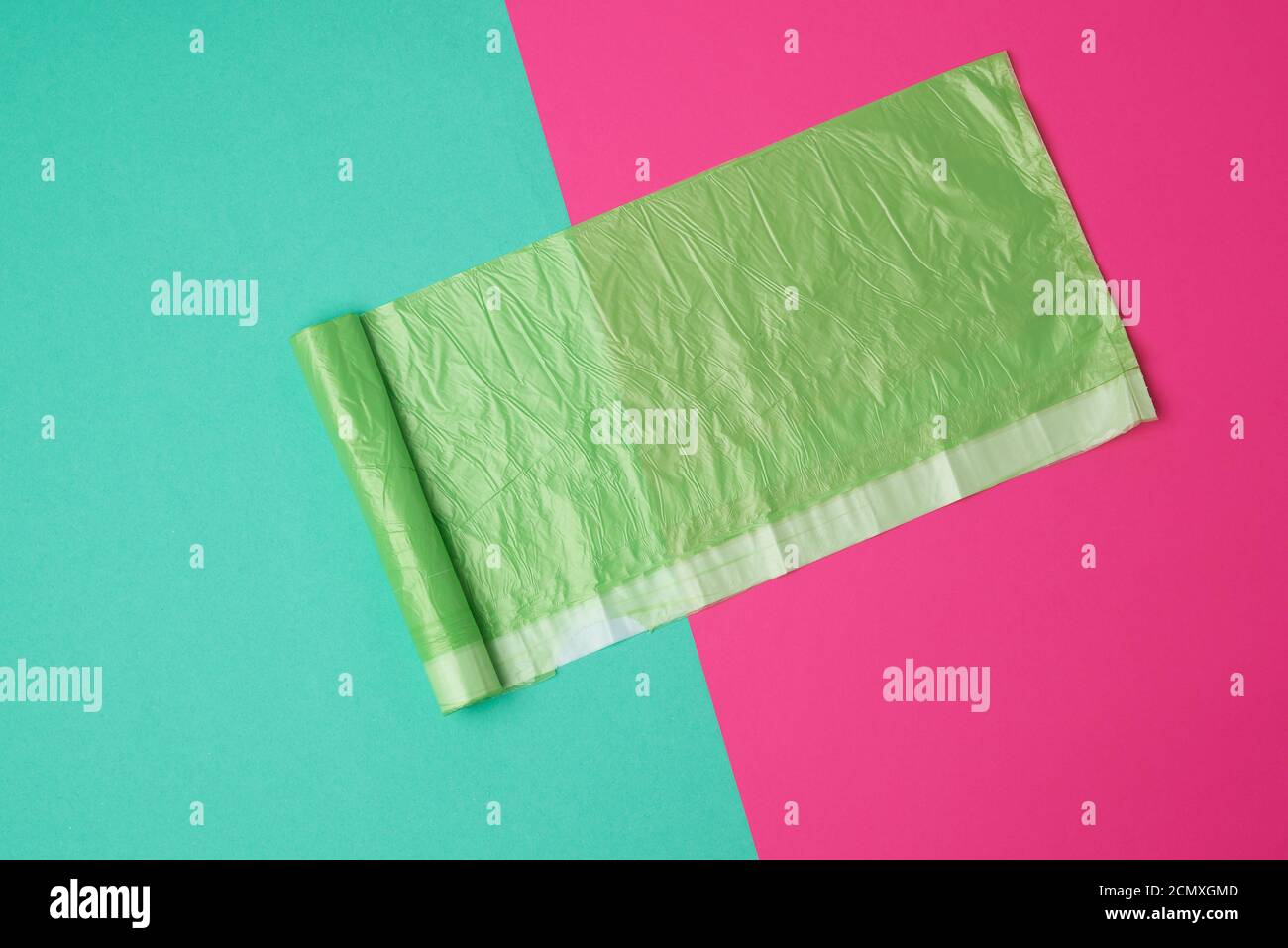 green transparent plastic bag for garbage on a colored background Stock Photo
