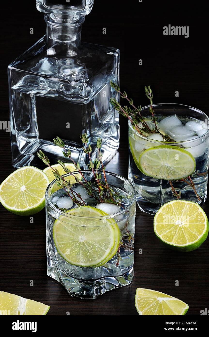 Cocktail with white rum and tonic, a slice of lime and thyme Stock