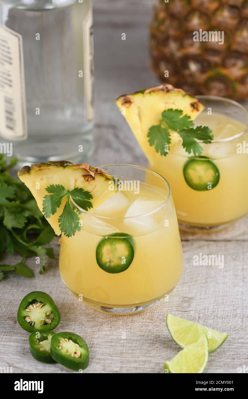 Tequila cocktail with pineapple juice, jalapeno slices and cilantro