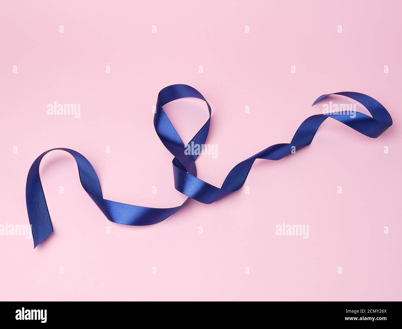 blue silk thin ribbon twisted on a pink background Stock Photo - Alamy