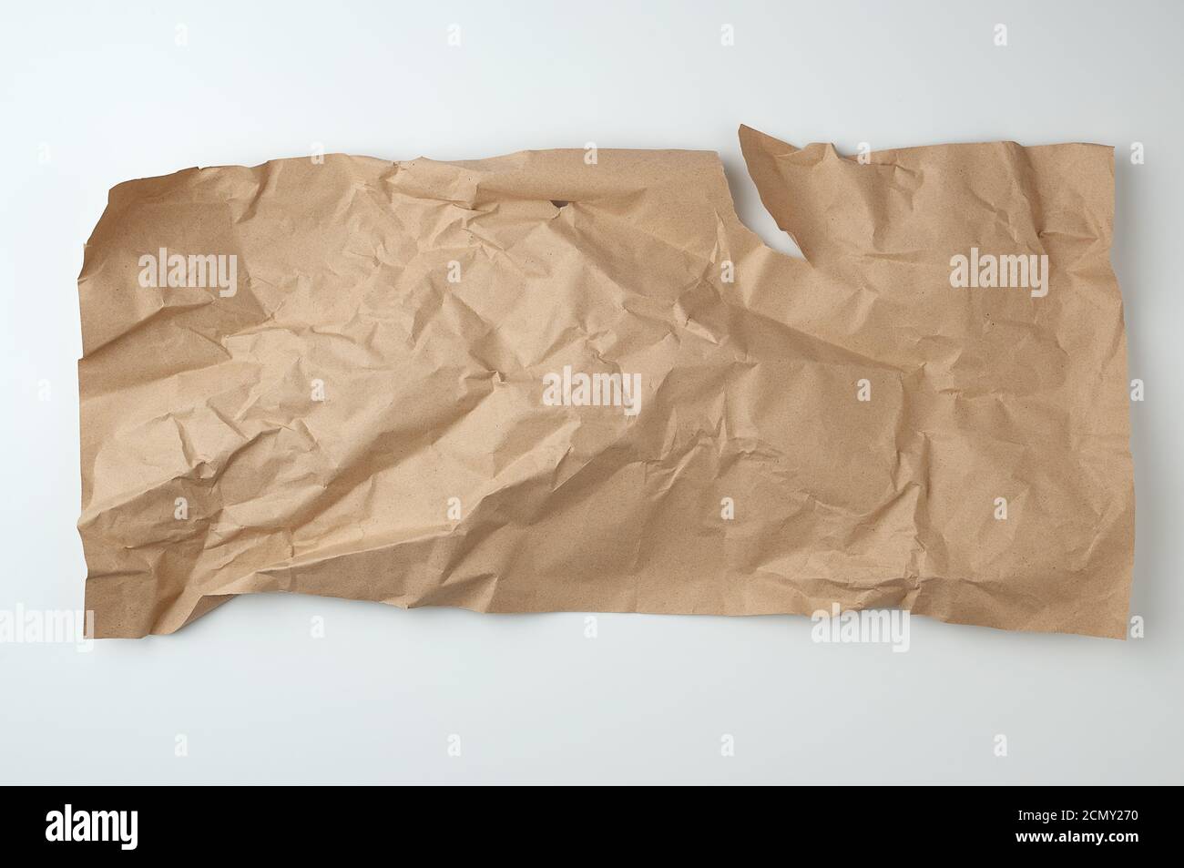 crumpled brown sheet of paper for packaging goods on white background