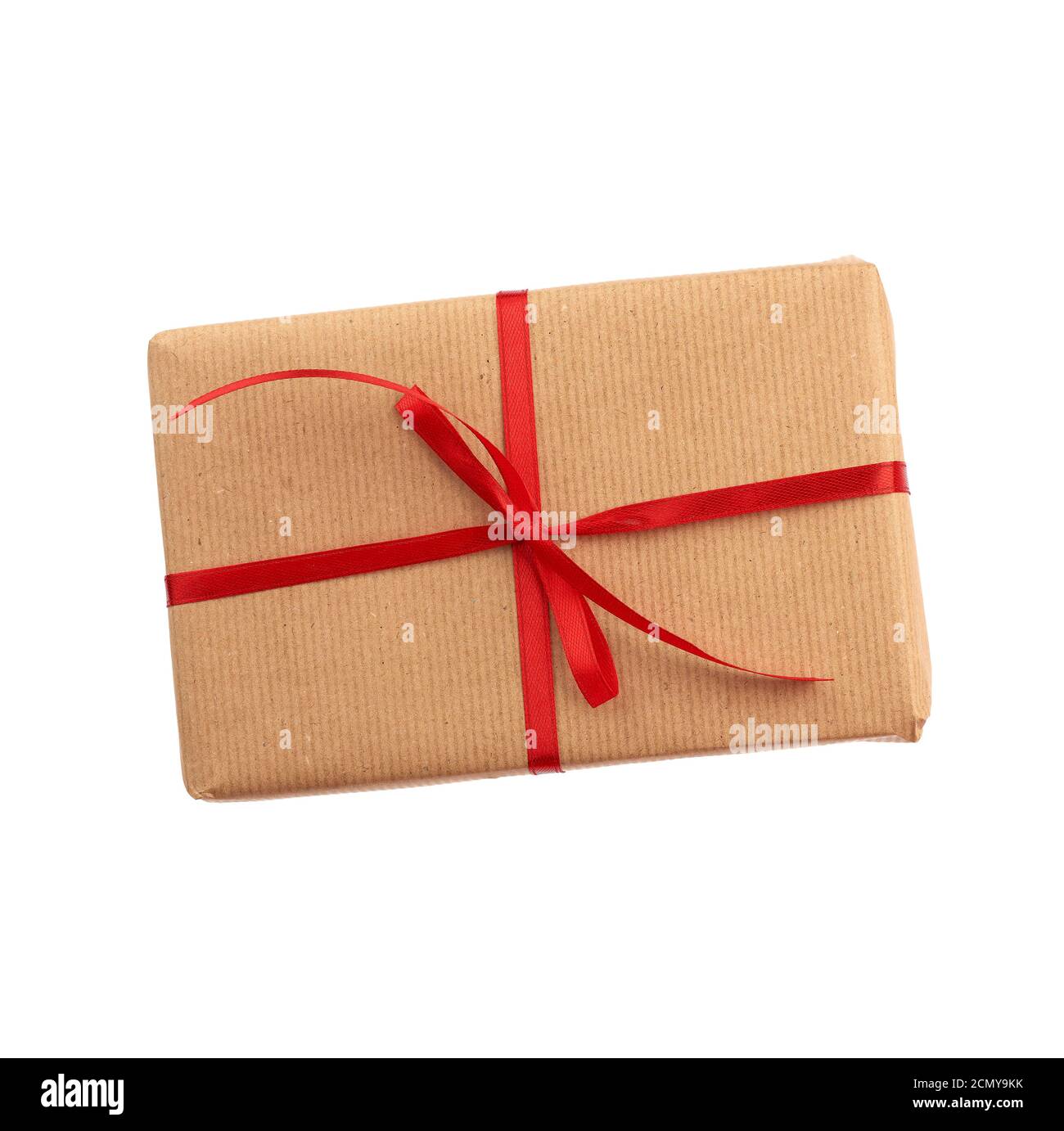 rectangular box wrapped in brown paper and tied with a red bow, gift isolated on white background, t Stock Photo