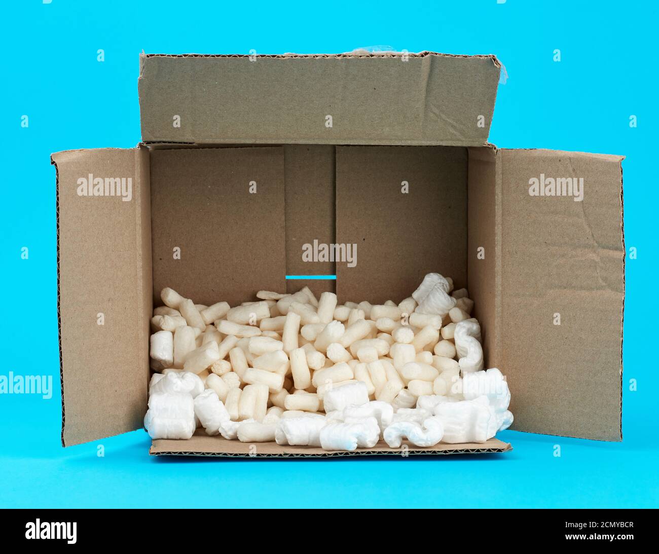 open rectangular brown cardboard box with white foam filling for transporting goods Stock Photo