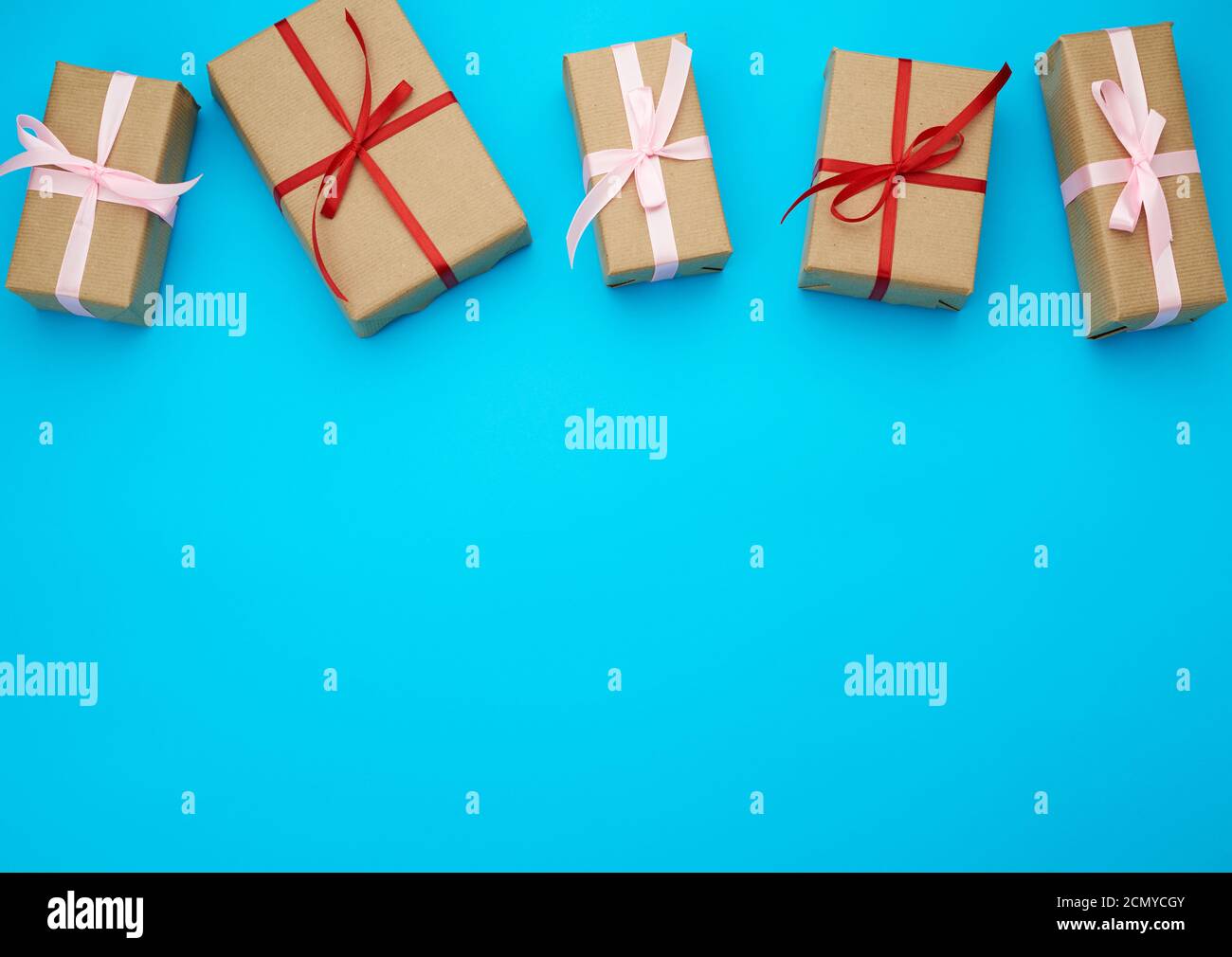 boxes wrapped in brown paper and tied with a red bow Stock Photo Alamy