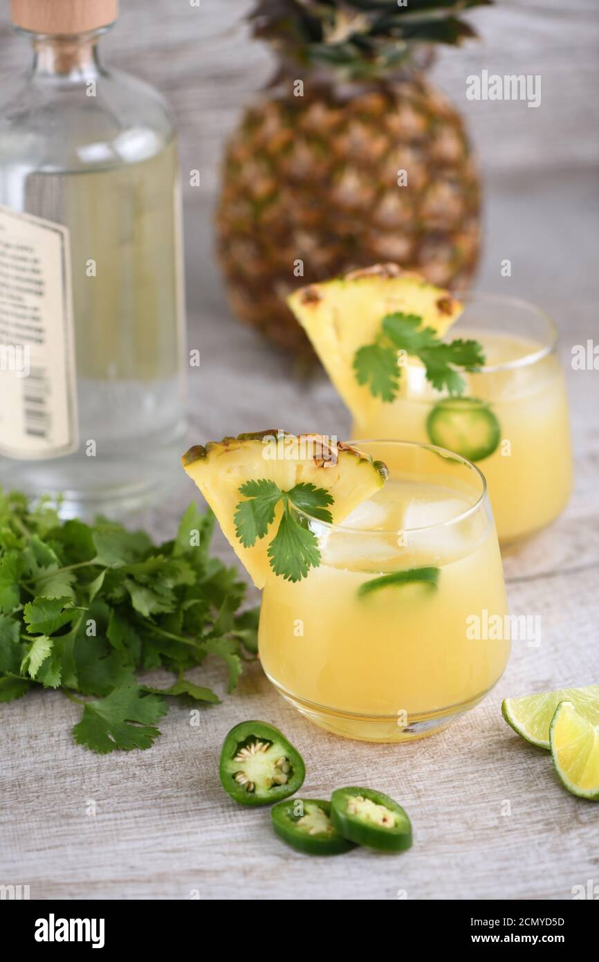Tequila cocktail with pineapple juice, jalapeno slices and cilantro, cooled with ice Stock Photo