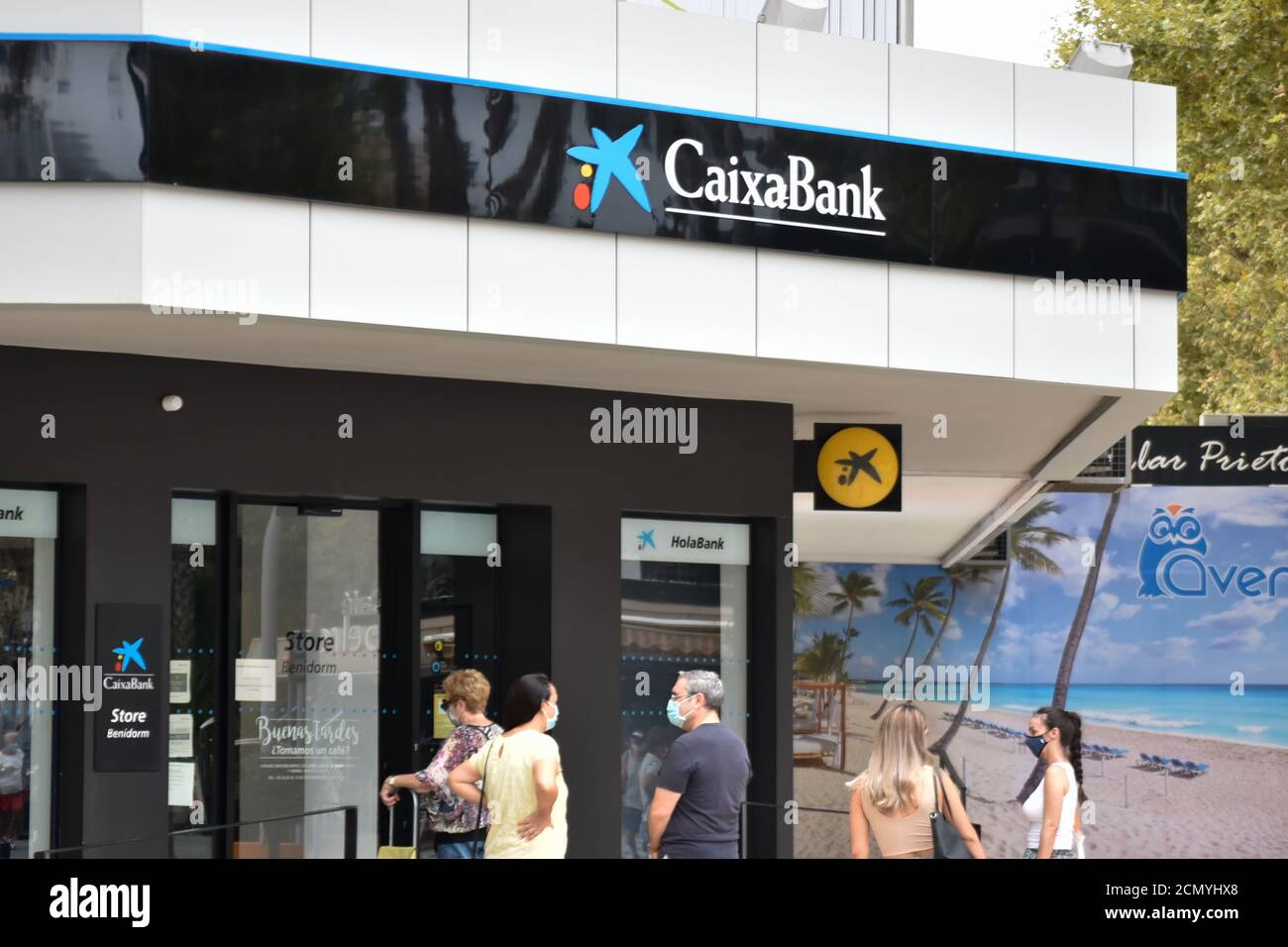 People wait at the entrance of Spanish bank, la caixa office in ...