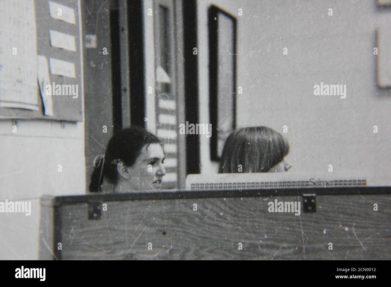 Fine 1970s vintage black and white photography of two girls playing the piano. Stock Photo