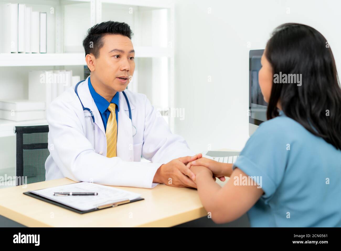 Close up of man doctor touching patient hand for encouragement and empathy on the hospital, cheering and support patient, Bad news, medical examinatio Stock Photo