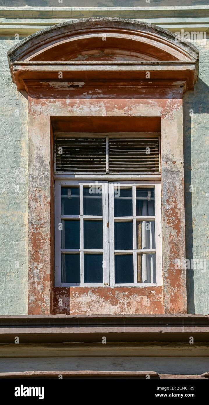 Mazatlan, Mexico - April 23, 2008: Closeup of stone framed window in palace building. chipped and faded paint. Stock Photo