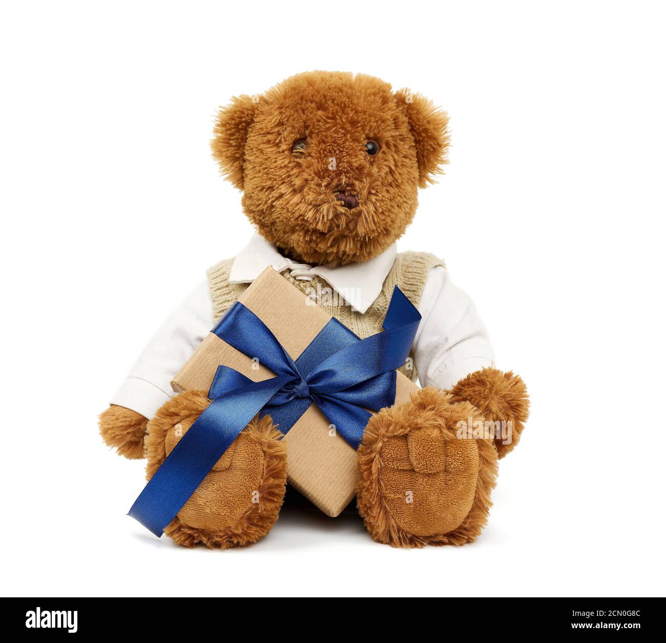 brown teddy bear sits on an isolated white background and holds a box ...