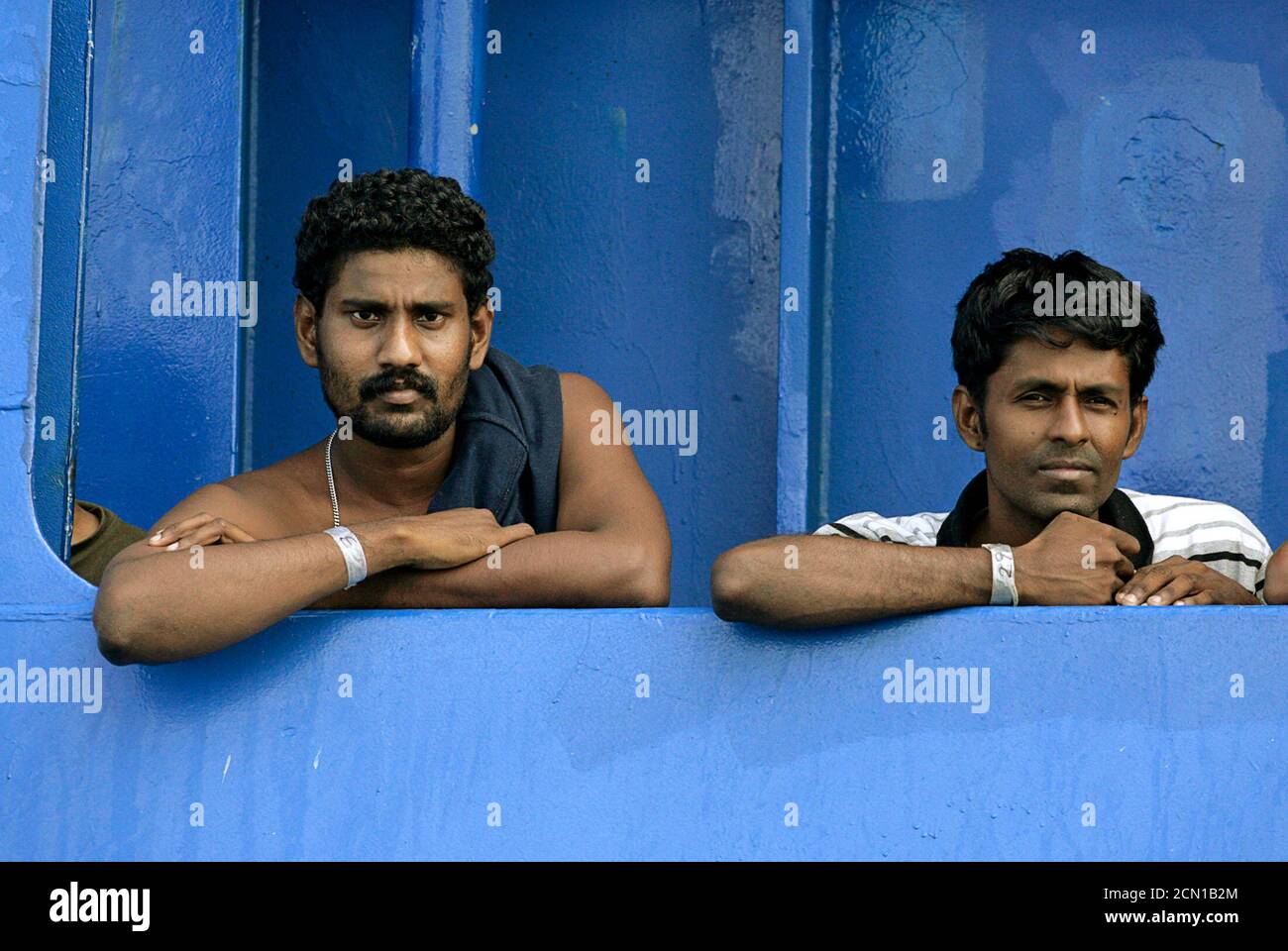 Sri Lankan refugees look out from the Australian coast guard vessel Oceanic Viking, anchored near Bengkil Island, about 14km (8.2 miles) east of Tanjung Pinang and the port of Kijang on the Indonesian island of Bintan, October 28, 2009. Seventy eight asylum seekers onboard the Oceanic Viking are waiting to be handed over to Indonesian authorities, according to the Australian Ministry of Home Affairs.     REUTERS/Vivek Prakash (INDONESIA POLITICS MILITARY SOCIETY) Stock Photo