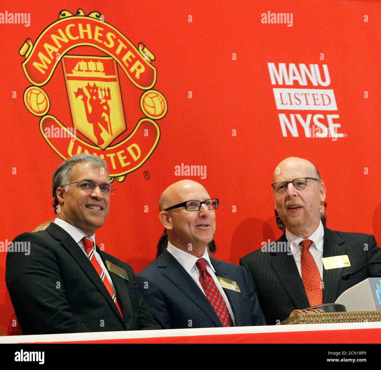 (L - R)Manchester United Chief Operating Officer (COO) Michael Bolingbroke and owners Joel and Avram Glazer ring the opening bell in celebration of Manchester United Ltd initial public offering on the floor of the New York Stock Exchange, August 10, 2012. Shares in Manchester United priced below expectations and were essentially flat in early trading on Friday, a disappointing stock market debut for the world's most famous soccer club and most valuable sporting team.REUTERS/Brendan McDermid (UNITED STATES - Tags: BUSINESS SPORT SOCCER) Stock Photo