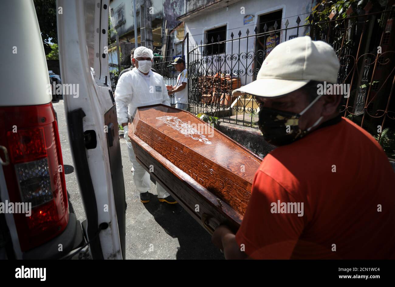 A relative and a worker of the Funeral SOS of the city of Manaus, wearing protective clothing, remove the coffin of Amadeu Garcia da Silva, 80, from his house, amid the coronavirus disease (COVID-19) outbreak, in Manaus, Brazil April 29, 2020. REUTERS/Bruno Kelly Stock Photo