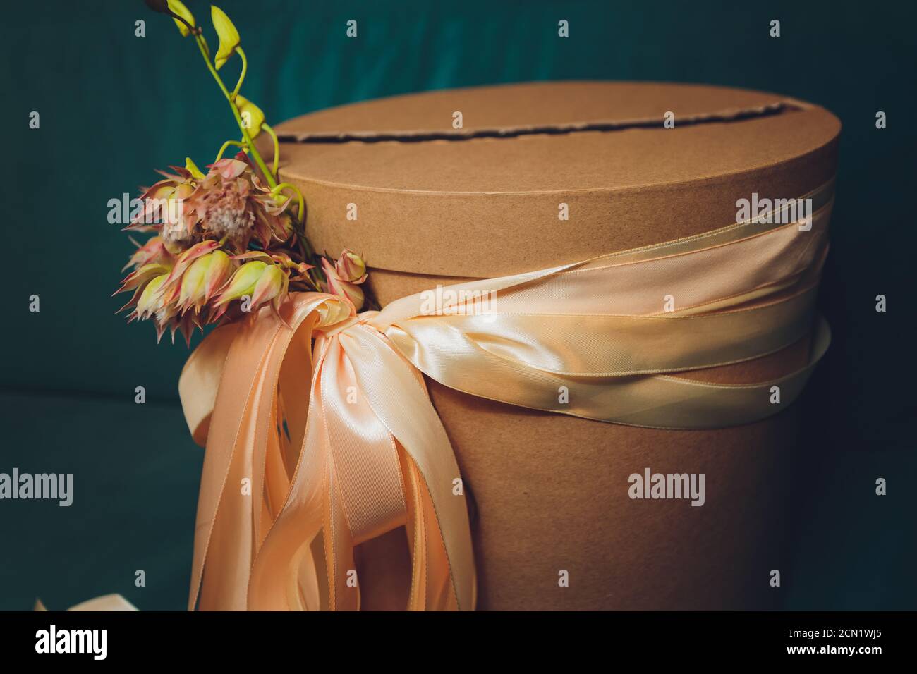 Rustic round brown gift box with ribbon and flower Stock Photo - Alamy