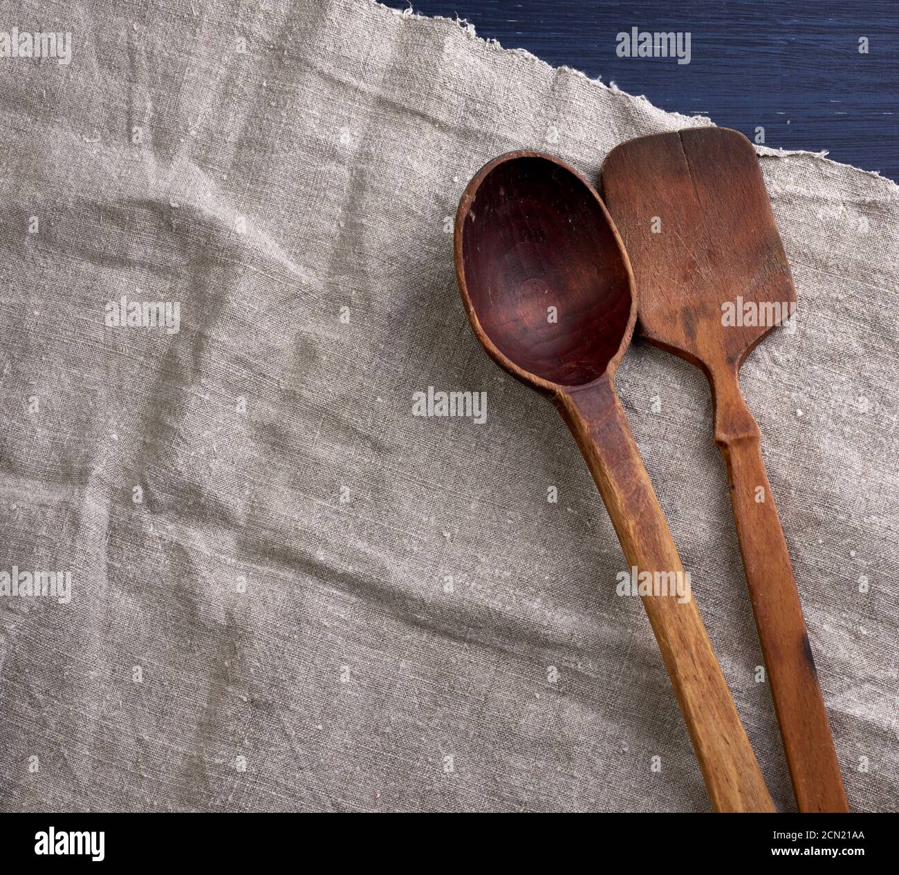 old empty brown wooden spoon on a gray surface Stock Photo