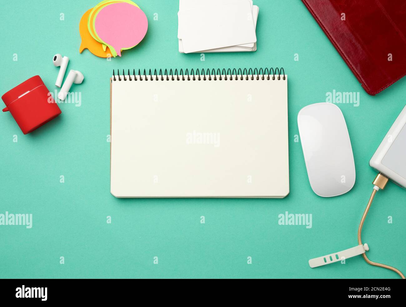 open notebook with blank white sheets, computer mouse, wireless headphones and charger Stock Photo