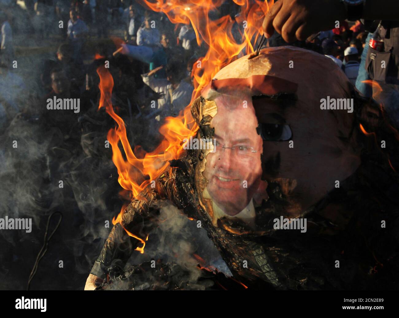 Demonstrators burn an effigy of Mexico's Finance Minister Luis Videgaray during a protest against the federal government's economic and tax reforms in Ciudad Juarez October 22, 2013. The Lower House maintained the government's plan to raise the lower 11 percent value-added tax (VAT) rate for border states to match the national rate of 16 percent.  REUTERS/Jose Luis Gonzalez (MEXICO - Tags: CIVIL UNREST POLITICS BUSINESS SOCIETY) Stock Photo
