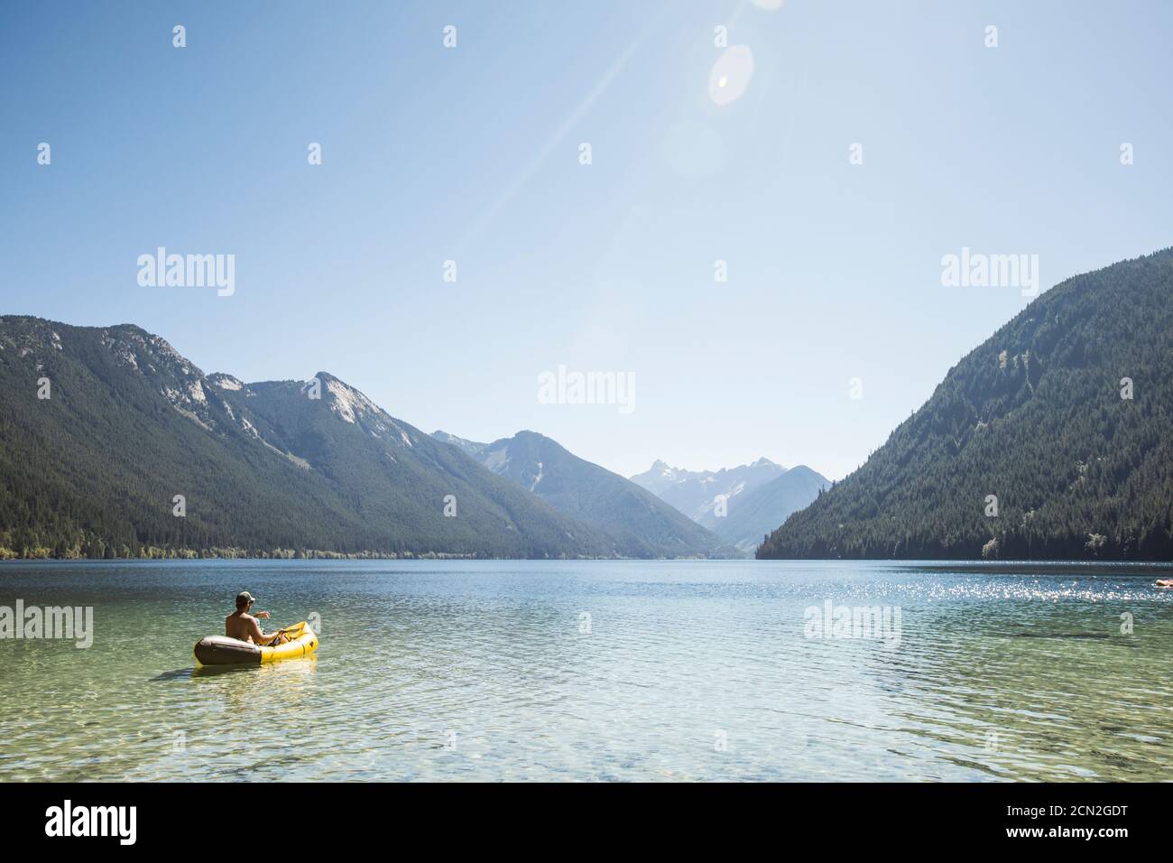 Rear view of man paddling inflatable boat on Chilliwack Lake. Stock Photo