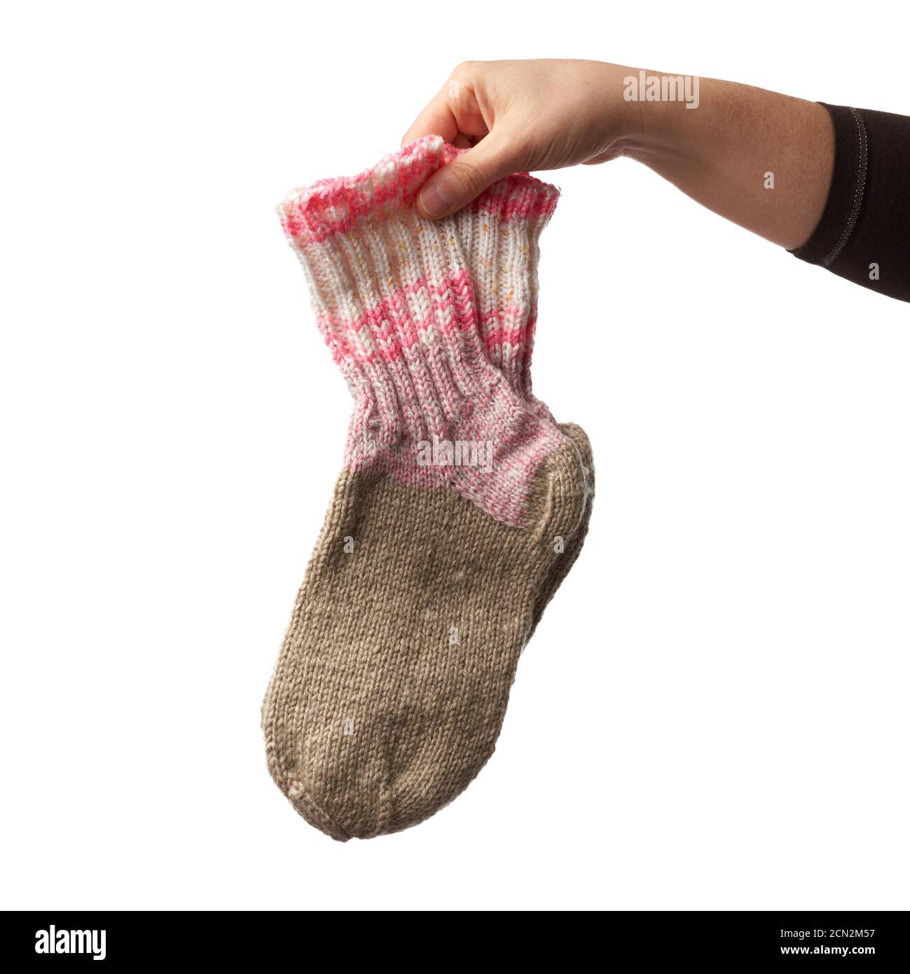 female hand holds a pair of knitted woolen socks, warm clothes Stock Photo