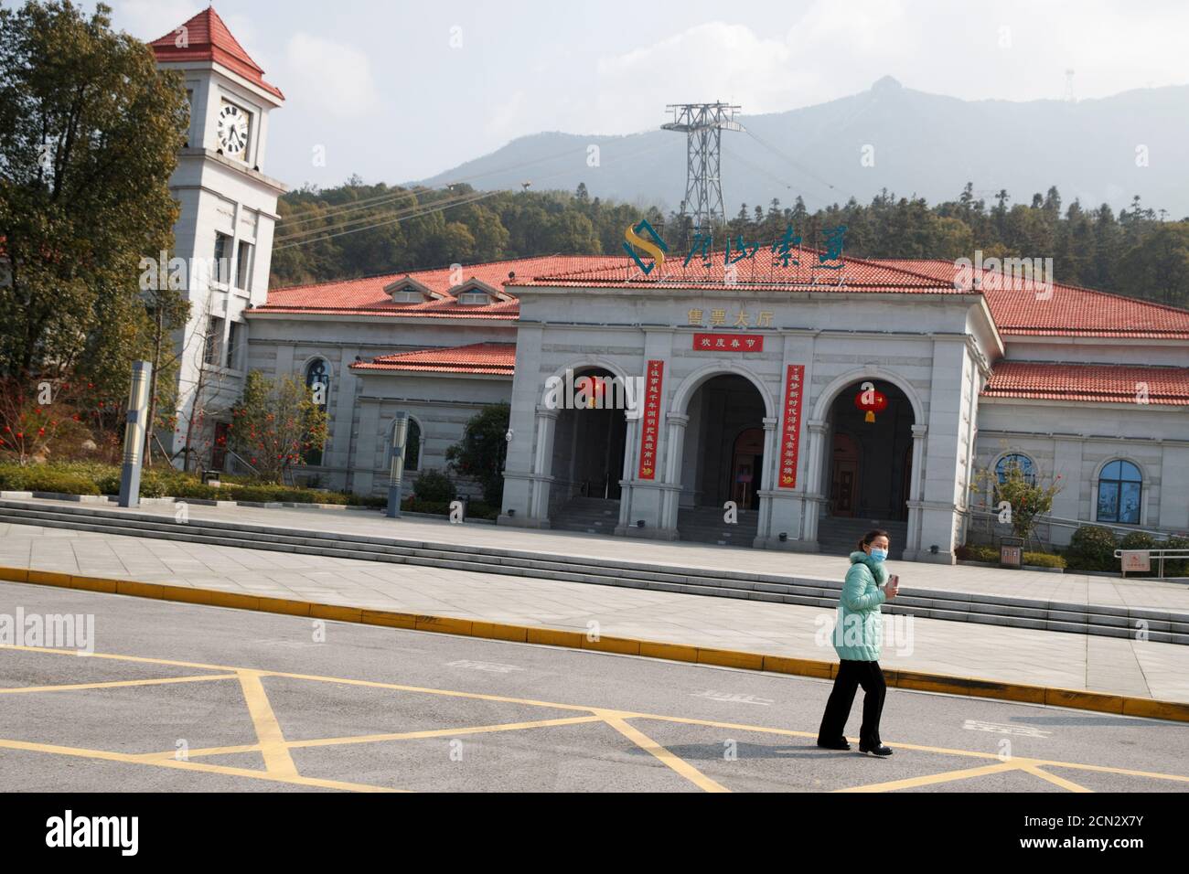 A woman walks outside the Lushan cable car station in Jiujiang, a major tourist destination in the area that is closed because of the corona virus outbreak, Jiangxi province, China, January 30, 2020. REUTERS/Thomas Peter Stock Photo