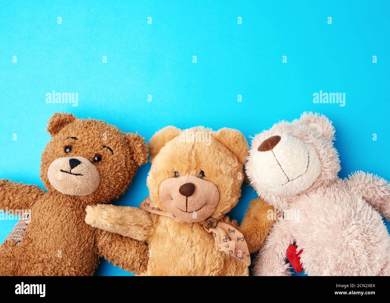 various teddy bears lie on a blue background head to head and look up Stock Photo