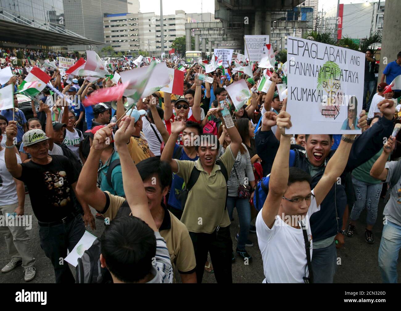 Protesters belonging to the Iglesia ni Cristo (Church of Christ) group march along EDSA highway in Mandaluyong, Metro Manila August 30, 2015. Thousands of members of the Christian group occupied the busy highway in Manila for a second night on Saturday, protesting against what they say is government intrusion in church affairs. The placard (R) reads,  'Fight for our religious belief'.  REUTERS/Romeo Ranoco Stock Photo