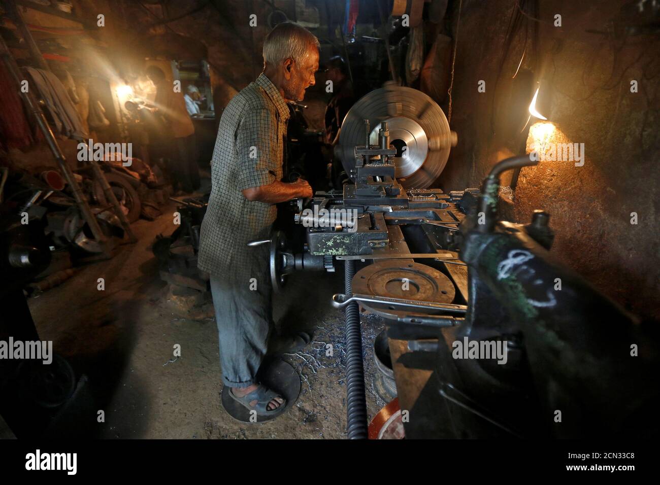 A worker operates a lathe as he makes spare parts of drilling machines at a workshop in Kolkata, India, June 10, 2016. REUTERS/Rupak De Chowdhuri Stock Photo