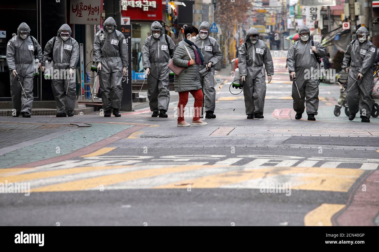 South Korean soldiers in protective gear sanitize a shopping street in Seoul, South Korea, March 4, 2020.    REUTERS/Heo Ran Stock Photo