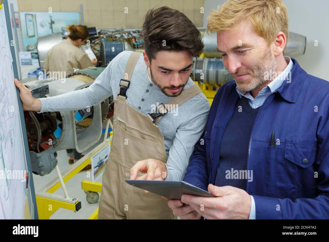 two men working in workshop looking at tablet Stock Photo