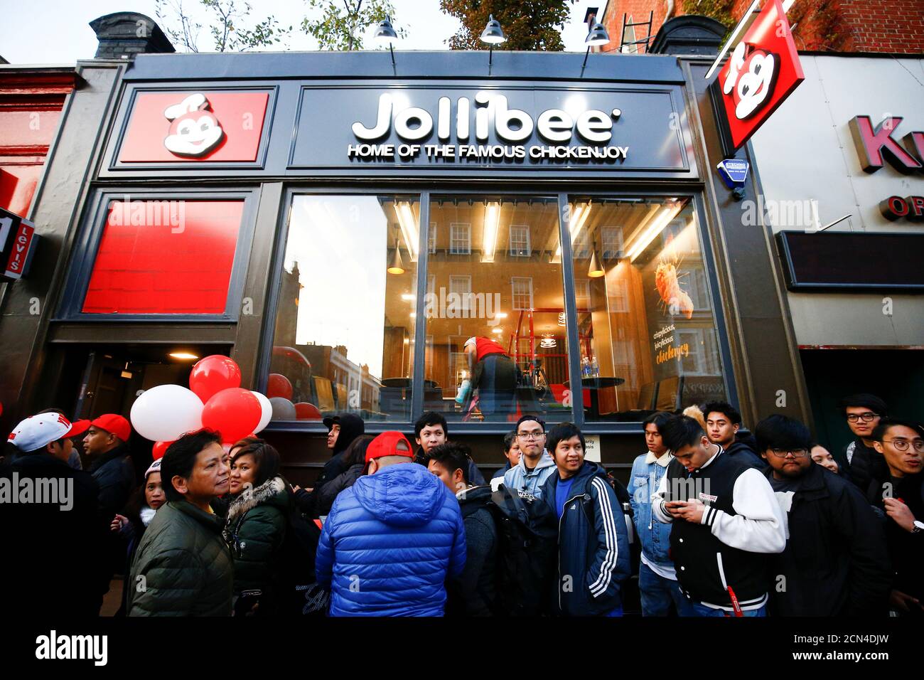 People queue ahead of the opening of the first Jollibee restaurant to open in the UK, in London, Britain October 20, 2018. REUTERS/Henry Nicholls Stock Photo