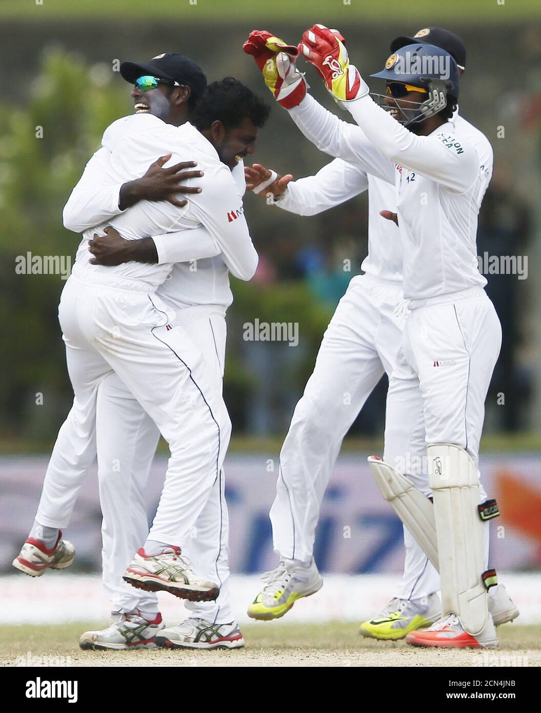Sri Lanka's Tharindu Kaushal (L) celebrates with captain Angelo Mathews (2nd L) and Dinesh Chandimal (R) after taking the wicket of India's Shikhar Dhawani (not pictured) during the fourth day of their first test cricket match against Sri Lanka in Galle August 15, 2015. REUTERS/Dinuka Liyanawatte Stock Photo