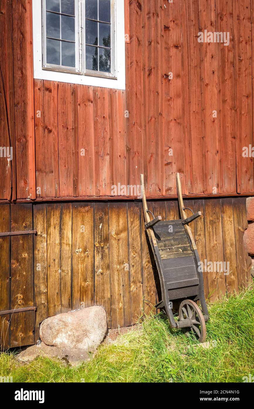 Old wooden wheelbarrow on a farm wall Stock Photo