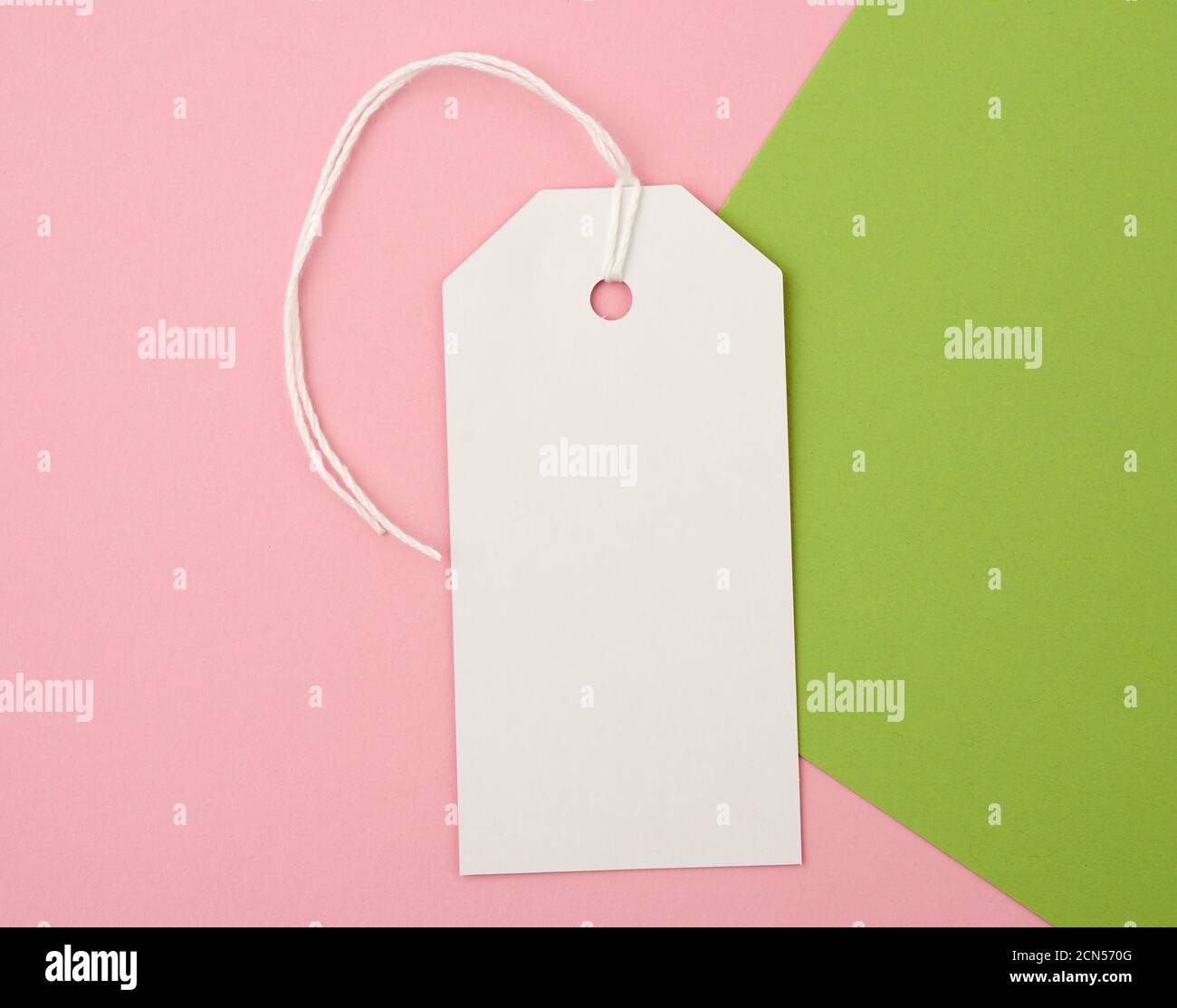 white paper rectangular tag on a rope on a colored background Stock Photo